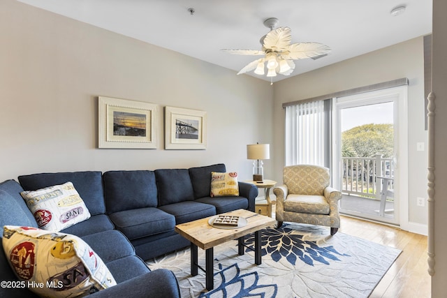living area with ceiling fan, baseboards, and light wood-type flooring