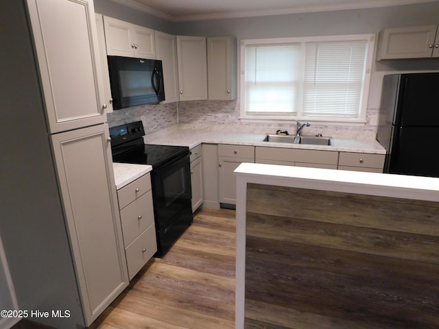 17261 Harvell Ln, Laurinburg, NC 28352 - kitchen with black appliances, a sink, ornamental molding, tasteful backsplash, and light countertops