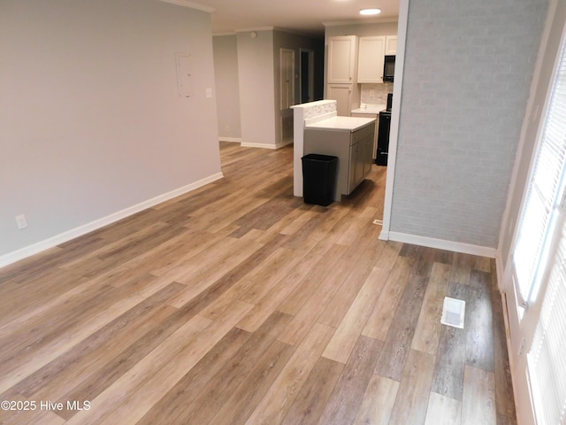 17261 Harvell Ln, Laurinburg, NC 28352 - unfurnished living room with baseboards, light wood finished floors, and crown molding