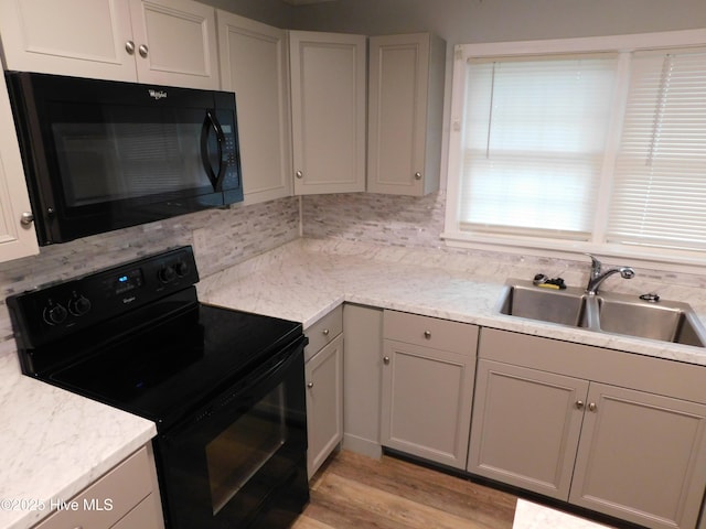 17261 Harvell Ln, Laurinburg, NC 28352 - kitchen featuring black appliances, a sink, gray cabinetry, light wood-style floors, and backsplash