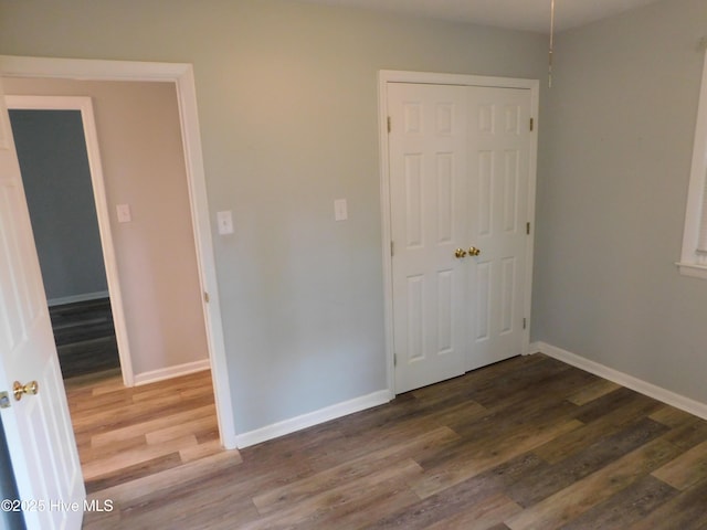 17261 Harvell Ln, Laurinburg, NC 28352 - unfurnished bedroom with wood finished floors, baseboards, and a closet
