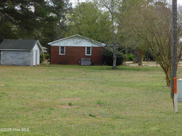 17261 Harvell Ln, Laurinburg, NC 28352 - view of green lawn with a storage unit, an outbuilding, and central AC unit