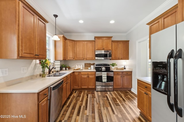 kitchen with appliances with stainless steel finishes, a sink, dark wood-style floors, brown cabinetry, and light countertops