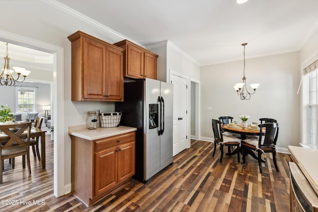 kitchen featuring stainless steel refrigerator with ice dispenser, a chandelier, dark wood-type flooring, ornamental molding, and brown cabinetry