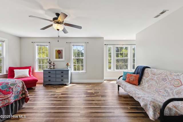 living area featuring wood finished floors, ceiling fan, and baseboards