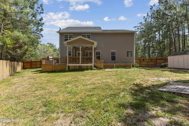 rear view of property with a shed, a deck, and an outbuilding