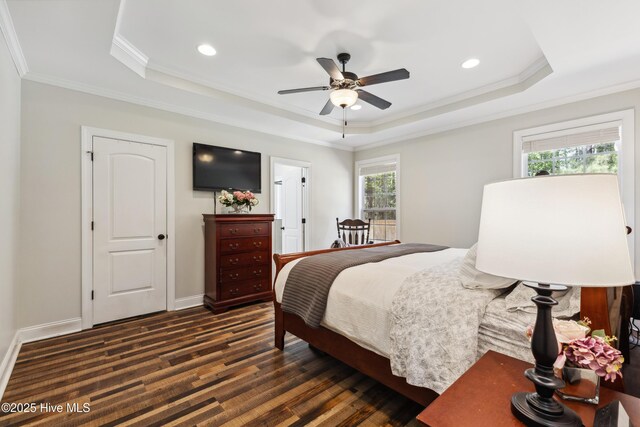 bedroom with a tray ceiling, crown molding, dark wood finished floors, recessed lighting, and a ceiling fan
