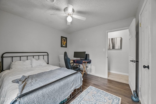 bedroom with baseboards, a textured ceiling, wood finished floors, and a ceiling fan