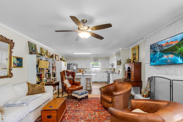living area featuring crown molding, a ceiling fan, and wood finished floors