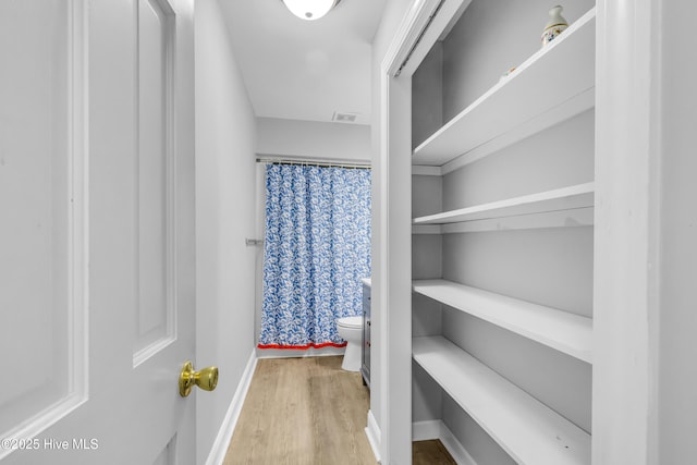 spacious closet featuring visible vents and wood finished floors