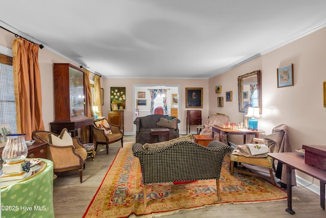 living area featuring ornamental molding and wood finished floors