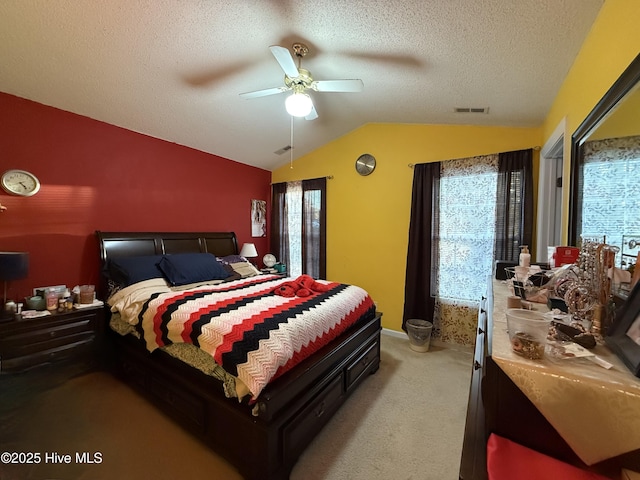 bedroom featuring visible vents, lofted ceiling, baseboards, light colored carpet, and a textured ceiling