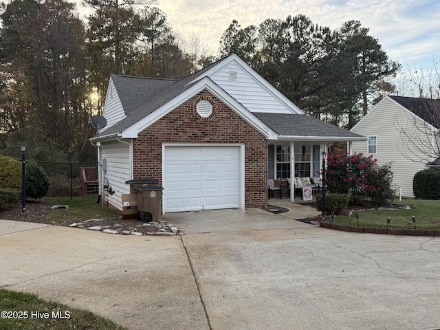 view of front of property featuring covered porch, driveway, roof with shingles, brick siding, and an attached garage
