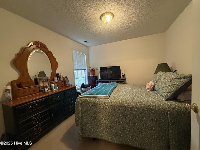 carpeted bedroom with a textured ceiling and visible vents