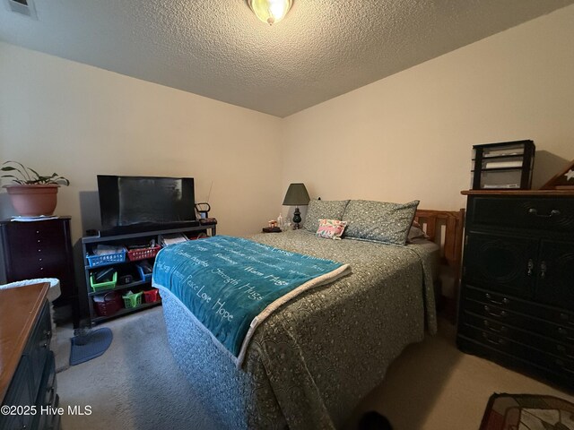 carpeted bedroom featuring a textured ceiling and visible vents