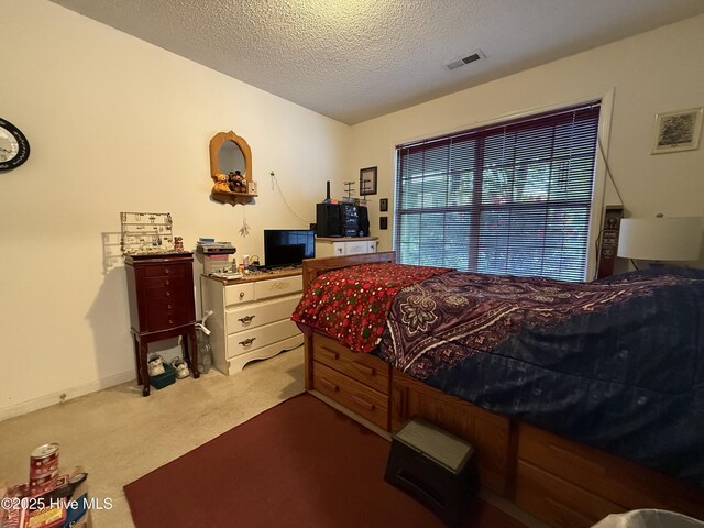 bedroom with carpet flooring, a textured ceiling, and visible vents