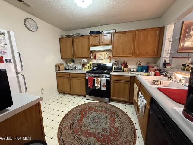 kitchen featuring visible vents, stainless steel gas stove, light floors, under cabinet range hood, and dishwasher
