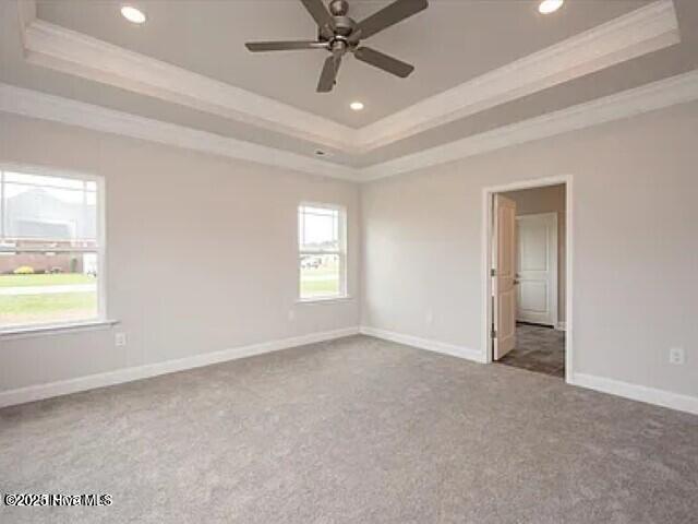 carpeted empty room with recessed lighting, a tray ceiling, ornamental molding, and a ceiling fan