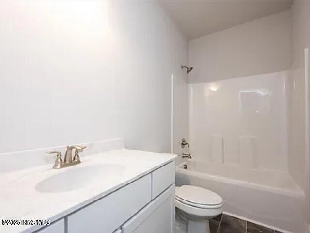 bathroom featuring vanity, tile patterned floors, bathing tub / shower combination, and toilet