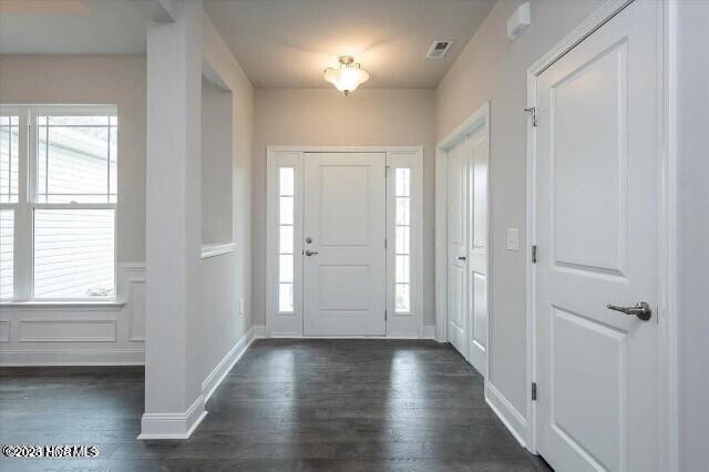 foyer with plenty of natural light, dark wood-style flooring, and visible vents