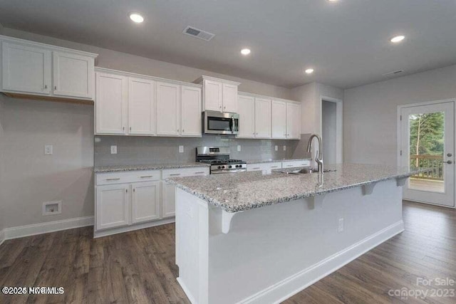 kitchen featuring white cabinets, appliances with stainless steel finishes, a sink, and visible vents
