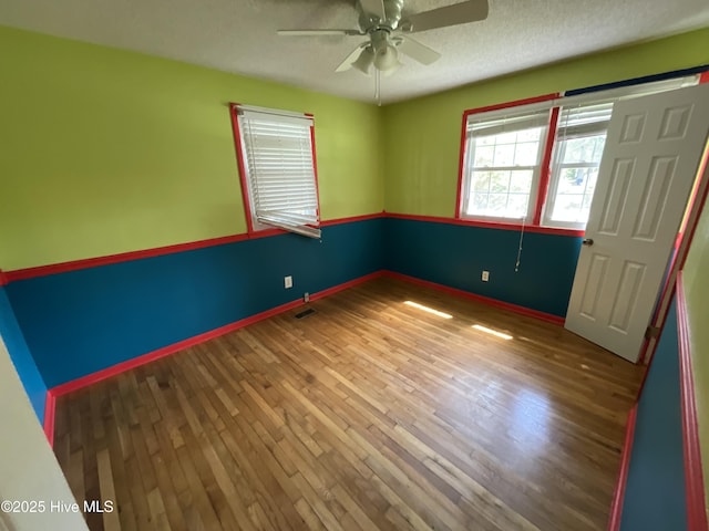 510 Sioux Dr, Jacksonville, NC 28540 - unfurnished room featuring wood finished floors, visible vents, a ceiling fan, baseboards, and a textured ceiling