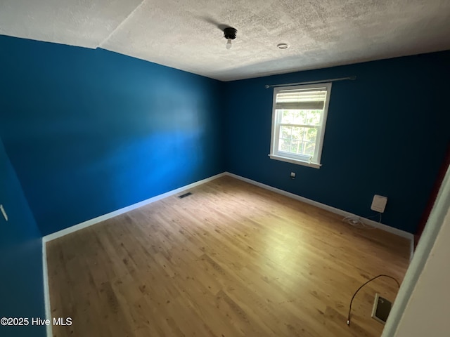 510 Sioux Dr, Jacksonville, NC 28540 - empty room featuring visible vents, baseboards, wood finished floors, and a textured ceiling