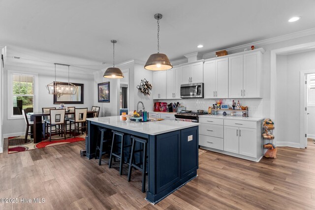 3763 Spicetree Dr, Wilmington, NC 28412 - kitchen featuring a breakfast bar, ornamental molding, light countertops, stainless steel appliances, and a sink