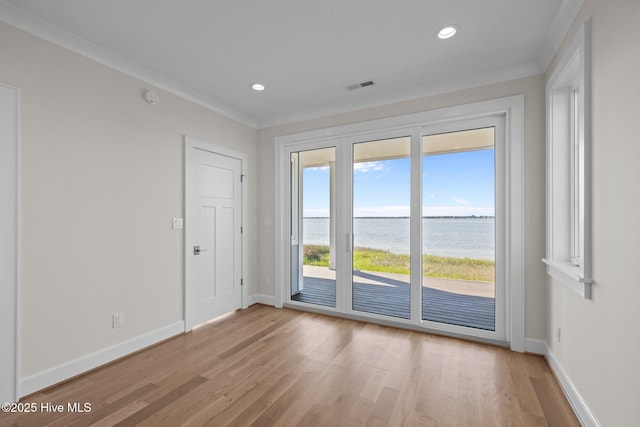entryway featuring light wood-style flooring, visible vents, baseboards, and a water view