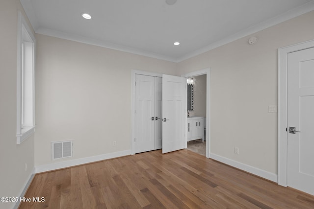 unfurnished bedroom with crown molding, wood finished floors, baseboards, visible vents, and recessed lighting