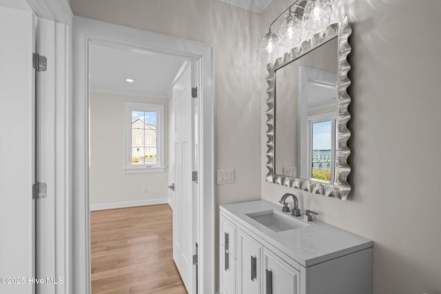 bathroom featuring baseboards, wood finished floors, recessed lighting, and vanity