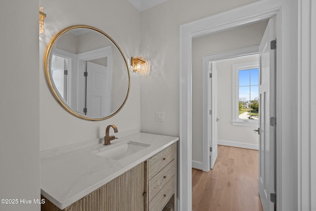 bathroom with baseboards, wood finished floors, and vanity