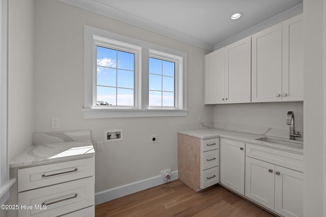laundry room with a sink, light wood-style floors, hookup for a washing machine, electric dryer hookup, and cabinet space