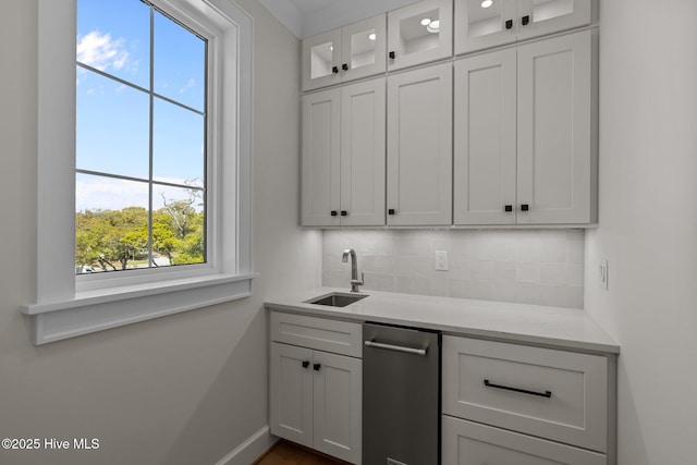 bar with backsplash, baseboards, and a sink