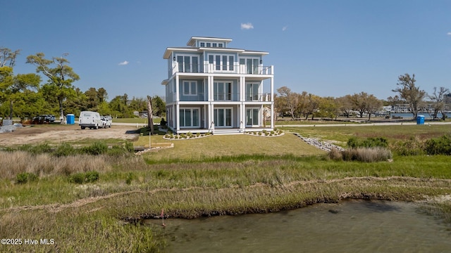 rear view of house featuring a water view and a balcony