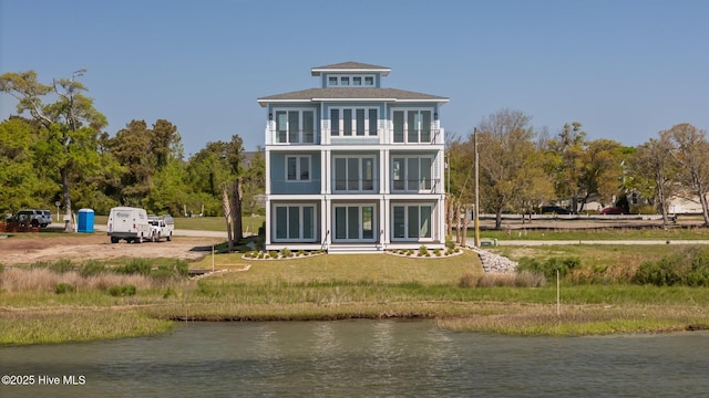 rear view of house with a balcony and a water view