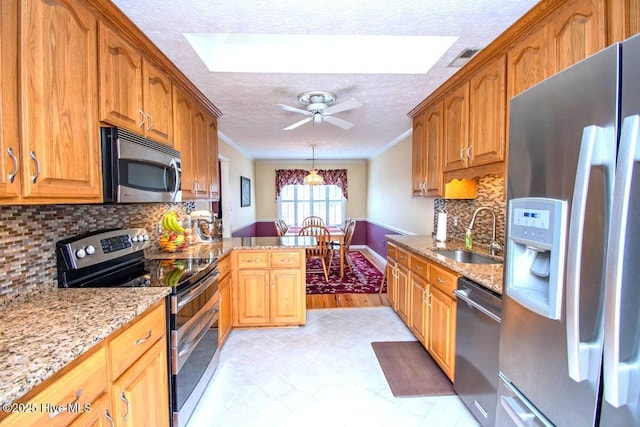 511 Pine Valley Dr, Morehead City, NC 28557 - kitchen featuring stainless steel appliances, a sink, a skylight, a textured ceiling, and crown molding