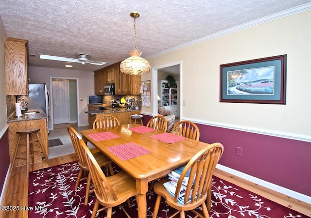 511 Pine Valley Dr, Morehead City, NC 28557 - dining area with light wood finished floors, baseboards, a textured ceiling, crown molding, and ceiling fan