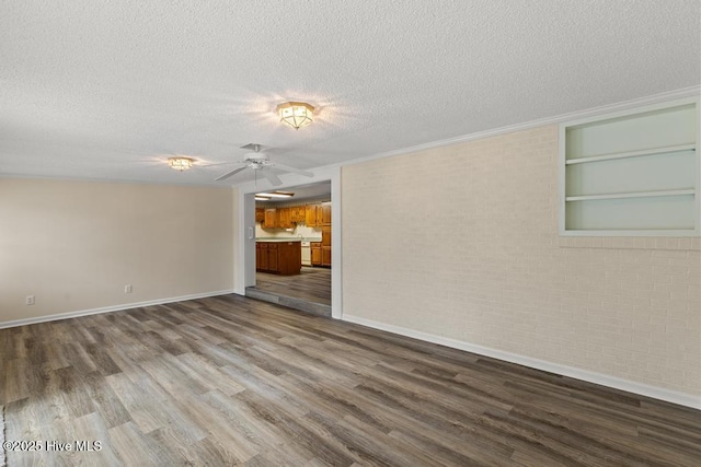 unfurnished living room featuring baseboards, a textured ceiling, a ceiling fan, built in shelves, and wood finished floors