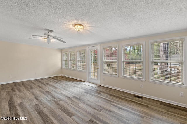 spare room with visible vents, baseboards, a ceiling fan, a textured ceiling, and wood finished floors