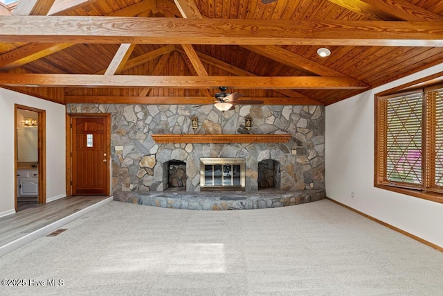 unfurnished living room with baseboards, a stone fireplace, visible vents, carpet, and wood ceiling