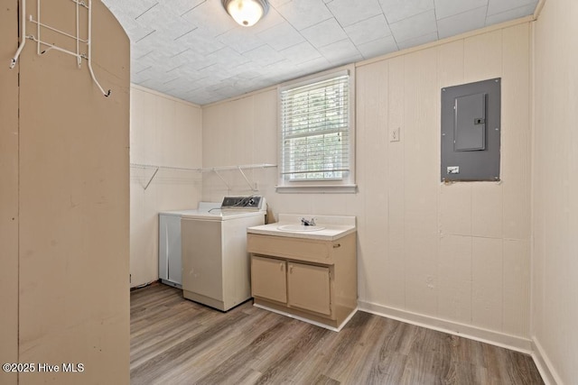laundry room with light wood finished floors, a sink, and electric panel