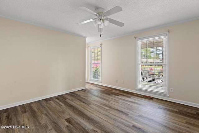 empty room featuring dark wood-type flooring, ornamental molding, a textured ceiling, and a healthy amount of sunlight
