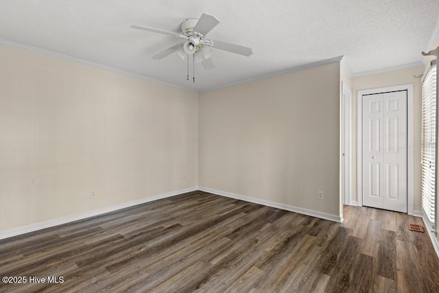 empty room featuring crown molding, wood finished floors, baseboards, and a ceiling fan