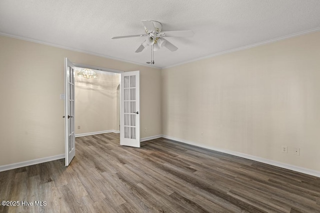 unfurnished room featuring ceiling fan with notable chandelier, ornamental molding, wood finished floors, french doors, and baseboards