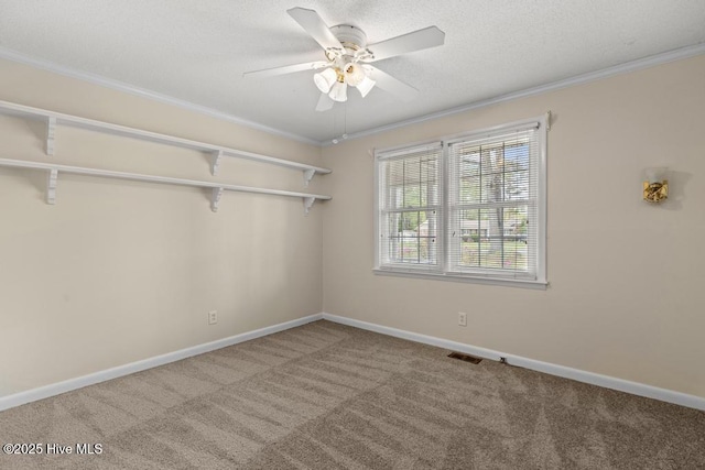 interior space featuring a ceiling fan, baseboards, ornamental molding, and carpet floors