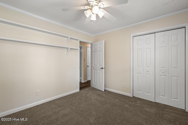 unfurnished bedroom featuring a closet, baseboards, ornamental molding, a ceiling fan, and carpet flooring