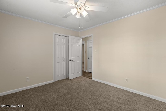 unfurnished bedroom with a closet, baseboards, ceiling fan, crown molding, and carpet flooring