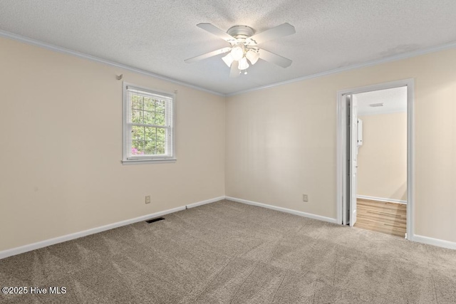 unfurnished room featuring carpet flooring, visible vents, and ornamental molding