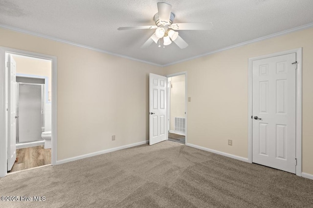 unfurnished bedroom with visible vents, a textured ceiling, crown molding, and carpet floors
